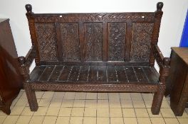 A LATE 19TH CENTURY AND LATER CARVED OAK SETTLE, approximate length 159.5cm