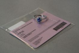 A 14K WHITE GOLD TANZANITE AND DIAMOND CLUSTER RING, ring size R, approximate weight 3.2 grams, (