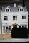 A MODERN WOODEN DOLLS HOUSE, modelled as a two storey town house, front opening to reveal three