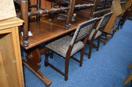 AN OAK REFRECTORY TABLE, with four upholstered chairs and two rush seated carver chairs (7)