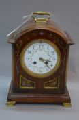 AN EARLY 20TH CENTURY WALNUT STAINED AND FLORAL PAINTED BRACKET CLOCK, brass carry handle to the