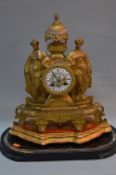 A LATE 19TH CENTURY GILT METAL MANTEL CLOCK, urn shaped finial with painted porcelain centre above