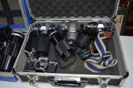 AN ALUMINIUM CASE CONTAINING OLYMPUS CAMERS AND LENSES, these include three OM10s and a iS300,