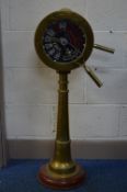 A REPRODUCTION BRASS ENGINE ROOM TELEGRAPH, mounted on a circular wooden base, height