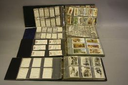 FOUR ALBUMS OF CIGARETTE CARDS, comprising full & part sets, manufacturers include Alexander