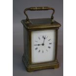 A BRASS CARRIAGE CLOCK, enamel dial, striking bell, approximately 12.5cm (key)