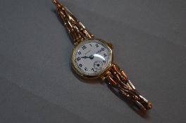 AN EARLY 20TH CENTURY LADIES ROLEX 9CT GOLD WRISTWATCH, white enamel dial, signed Rolex, Arabic