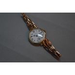 AN EARLY 20TH CENTURY LADIES ROLEX 9CT GOLD WRISTWATCH, white enamel dial, signed Rolex, Arabic