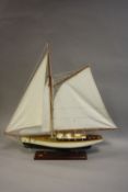 A WOODEN DISPLAY YACHT MODEL, in need of minor attention, length approximately 63cm x width 13cm,