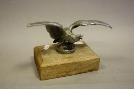 A CHROME PLATED CAR RADIATOR CAP/MASCOT IN THE FORM OF AN EAGLE, wingspan approximately 20cm,
