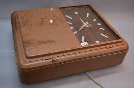 A MID 20TH CENTURY METAL CASED ELECTRIC WALL CLOCK, the rectangular wood effect dial named '