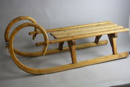 A MID 20TH CENTURY WOODEN SLEDGE, on metal runners, bears signatures in black ink to the