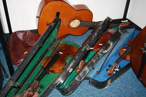 THREE CASED DISTRESSED VIOLINS, (all with bows) and a Tatra classic guitar, with soft case, two