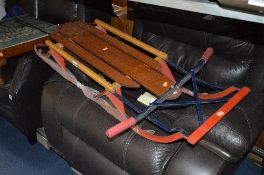 A VINTAGE STRETCHERED WOODEN SLEDGE, with steering handles to front