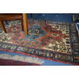 A 20TH CENTURY WOOLLEN RUG OF PERSIAN STYLE, predominately blue, cream and red, with geometric and