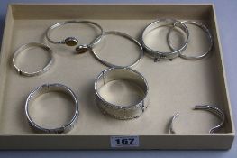 A MIXED SELECTION OF EIGHT SILVER AND OTHER BANGLES