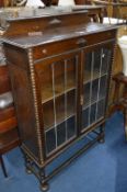 AN OAK BARLEY TWIST LEAD GLAZED TWO DOOR BOOKCASE