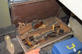 A CARPENTERS TOOL CHEST CONTAINING VINTAGE TOOLS, including wooden moulding planes, saws, chisels