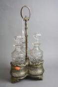 A PLATED THREE BOTTLED TANTALUS, with pierced decoration, together with three cut glass decanters