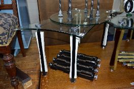 A GLASS TOPPED COFFEE TABLE, on modern contemporary legs and four similar spare legs (5)