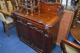 A VICTORIAN PITCH PINE CHIFFIONIER, with carved floral, grape and vine raised back