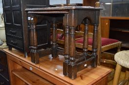 AN OAK SEWING BOX, an oak nest of two tables and two rush seated stools (4)