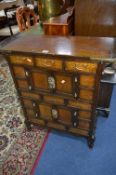 AN OAK ORIENTAL STYLE CHEST, of three small drawers above two double door cupboard compartments,