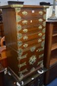 AN OAK ORIENTAL STYLE BRASS BOUNDED CHEST, of five drawers above double cupboard doors,