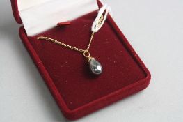 A 9CT BLACK PEARL PENDANT AND CHAIN