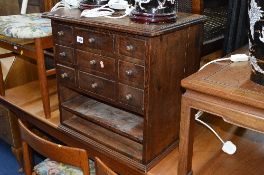 A SMALL STAINED PINE CHEST OF DRAWERS, with three small drawers either side of three long drawers,