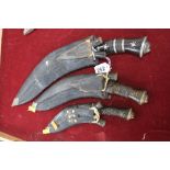 THREE GRADUATING GURKHA KUKRI KNIVES, complete with scabbard and two small knives in each