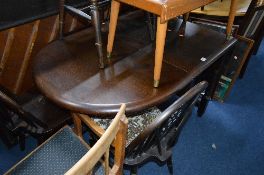 A DARK OAK DROP LEAF DINING TABLE, with four wheelback chairs (5)
