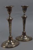 A PAIR OF EDWARDIAN OVAL SILVER CANDLESTICKS, banded rims to sconces, embossed to candle holders,