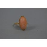 A SINGLE STONE OVAL CABOCHON CUT CORAL RING, coral measuring approximately 21mm x 12mm, ring size