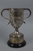 A LATE VICTORIAN TWIN HANDLED TROPHY CUP, foliate embossed decoration, engraved 'AEI LAMP AND