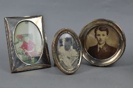 THREE GEORGE V SILVER PHOTOGRAPH FRAMES, all with wooden easel backs, circular frame, Birmingham