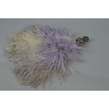 A GEORGE V SILVER HANDLED LILAC OSTRICH FEATHER FAN, the handle embossed as a young woman with