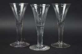 THREE MID 18TH CENTURY WINE GLASSES, funnel shaped bowls, plain stems, heights approximately 16.