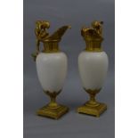 A PAIR OF CONTINENTAL ORMOLU AND WHITE MARBLE EWER MANTELPIECE ORNAMENTS, the handle cast as cherubs