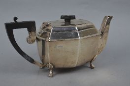 A GEORGE VI SILVER TEAPOT, of shaped rectangular form, ebony fittings and on four angular pad