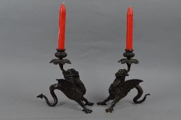 A PAIR OF BRONZE DRAGON CANDLESTICKS, the dragons cast with two front legs, the curled tail acting