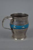 AN EDWARDIAN ARTS & CRAFTS STYLE HAND HAMMERED SILVER AND TURQUOISE ENAMEL CHRISTENING MUG, of