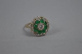 A LATE 20TH CENTURY EMERALD AND DIAMOND ROUND CLUSTER RING, estimated total round brilliant cut