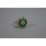 A LATE 20TH CENTURY EMERALD AND DIAMOND ROUND CLUSTER RING, estimated total round brilliant cut