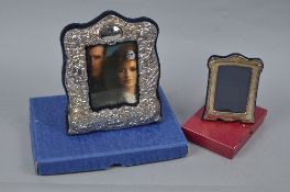AN ELIZABETH II SILVER MOUNTED EASEL BACK PHOTOGRAPH FRAME, cast with cherubs and scrolls, maker