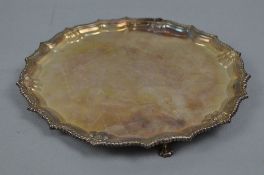 AN ELIZABETH II CIRCULAR SILVER SALVER, gadrooned pie crust edge, on three cabriole legs with paw