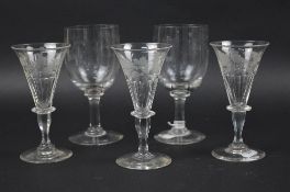 A SET OF THREE EARLY 19TH CENTURY WINE GLASSES, funnel shaped bowls engraved with fruit and exotic