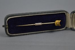 AN EARLY 20TH CENTURY FOX HEAD STICK PIN, textured head with rose cut diamond set eyes, together