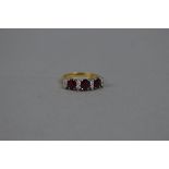 A LATE 20TH CENTURY 18CT GOLD RUBY AND DIAMOND HALF HOOP RING, three oval mixed cut rubies measuring