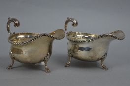 A PAIR OF GEORGE V SILVER SAUCEBOATS, gadrooned rims, 'S' scroll handle, three cabriole legs with